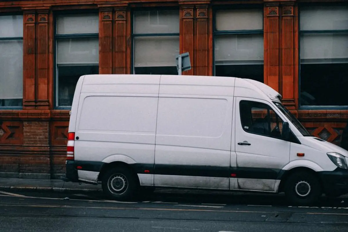 Weißer Sprinter parkt vor einem Backsteingebäude